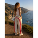 Woman standing on a coastal path with scenic ocean view