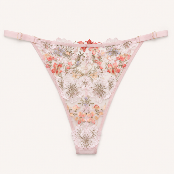 Light pink lace thong panties with floral embroidery and a scalloped edge, displayed flat against a light off-white background.