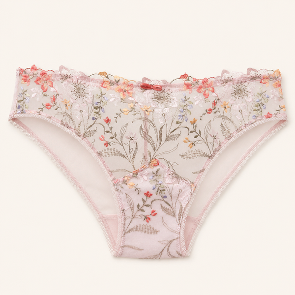 Light pink floral lace panties with a delicate ruffled waistband, featuring embroidered botanical patterns in soft pink, red, orange, and green on a cream mesh base, shown flat against a light beige background.
