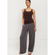 A woman modeling a dark brown ribbed tank top and wide-leg charcoal gray pants against a plain white studio background.