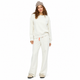 A woman modeling a matching cream sweatshirt and wide-leg sweatpants lounge set, styled with a beige knit beanie and beige slip-on shoes against a solid white background.