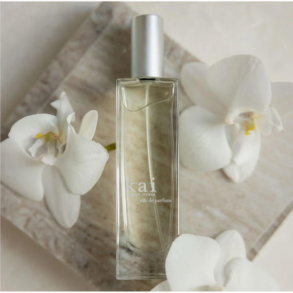 Perfume bottle labeled 'kai' with white flowers on a light background