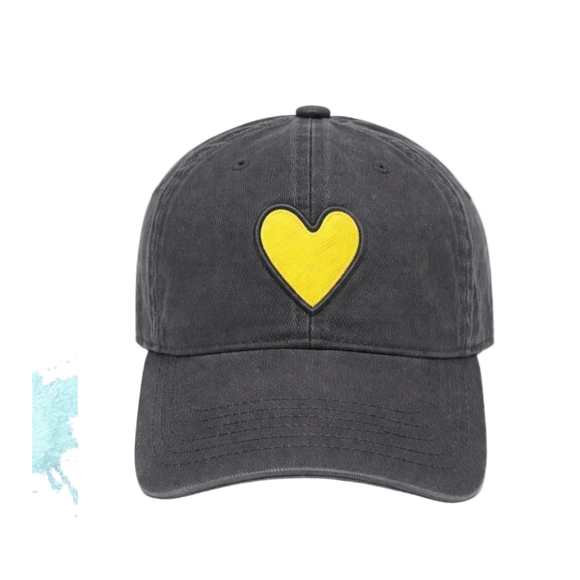 A dark gray washed cotton baseball cap featuring a prominent yellow heart patch with a black stitched border on the front, set against a plain white background.