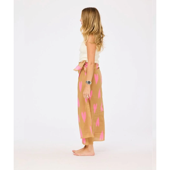 Woman wearing a beige skirt with pink heart patterns on a white background