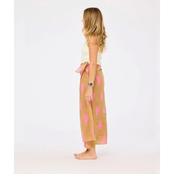 Woman wearing a beige skirt with pink heart patterns on a white background