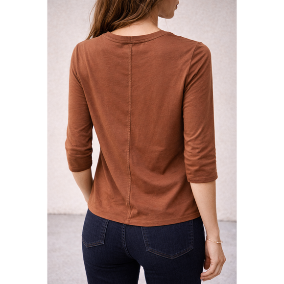 Brown long-sleeve top worn by a person against a neutral background