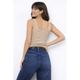 Woman wearing a beige tank top and blue jeans against a white background