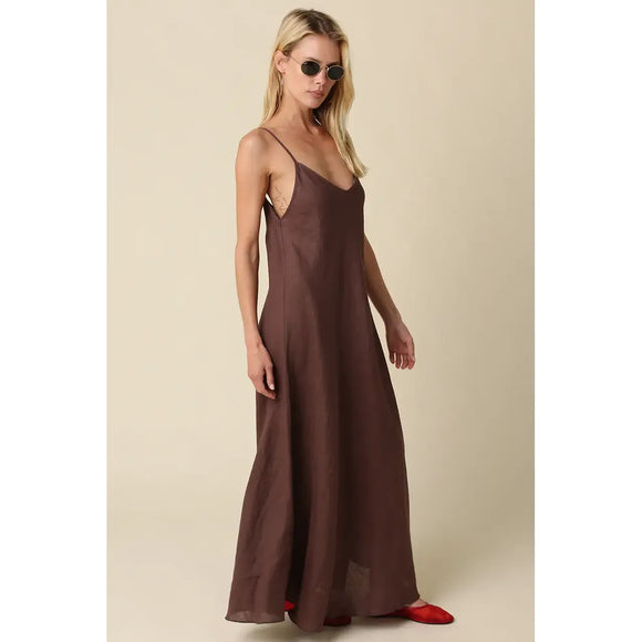 Woman wearing a brown slip dress against a beige background