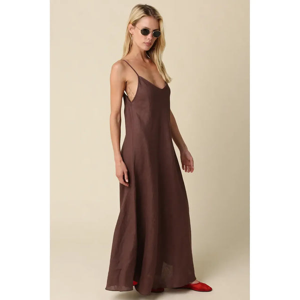 Woman wearing a brown slip dress against a beige background