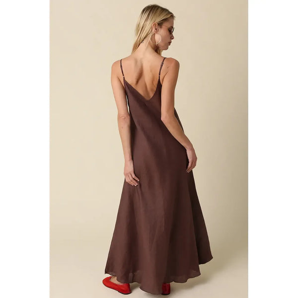 Woman wearing a brown slip dress with a beige background