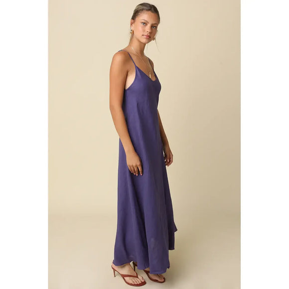 Woman wearing a long purple dress against a beige background