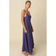Woman wearing a long purple dress against a beige background