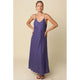 Woman wearing a long purple dress against a beige background