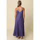 Woman wearing a purple slip dress against a beige background