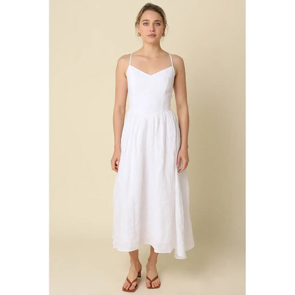 Woman wearing a white dress against a beige background