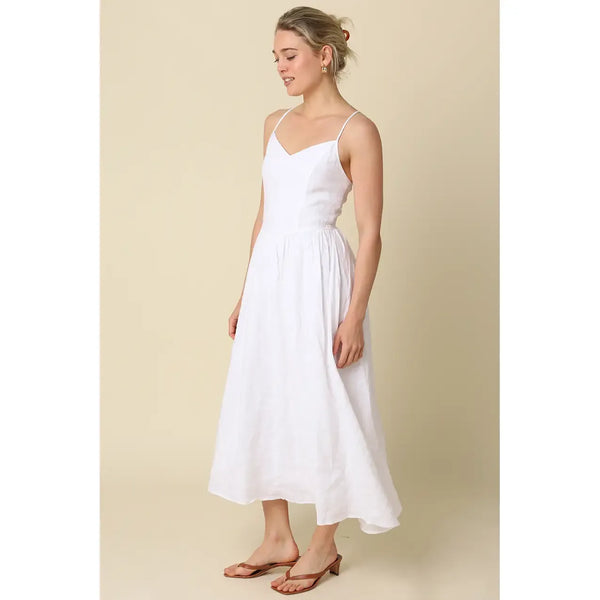 Woman wearing a white dress against a beige background