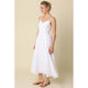 Woman wearing a white dress against a beige background