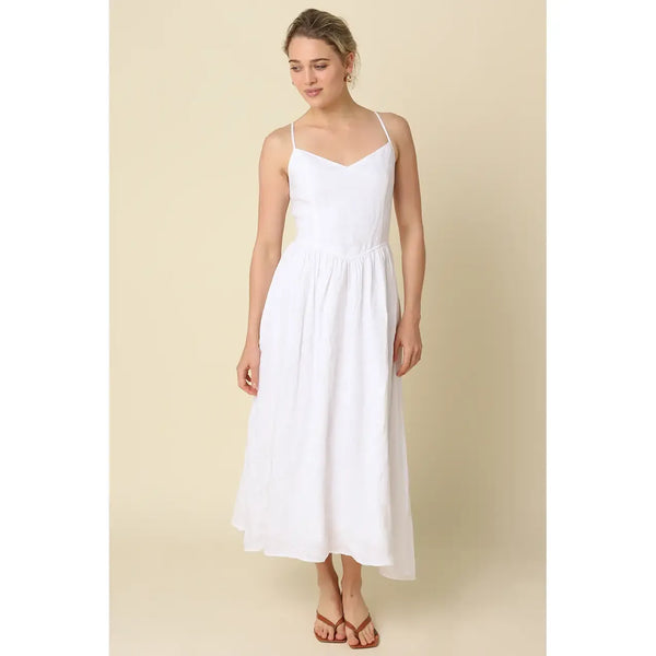 Woman wearing a white dress against a beige background