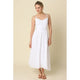 Woman wearing a white dress against a beige background