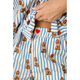 Close-up of a person wearing blue and white striped pajama pants with a repeating print of poodles wearing red hats, and a matching top partially visible.