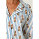 Close-up of a person wearing a collared button-front shirt with blue vertical stripes and an allover print of brown poodles wearing red berets.