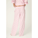 A person wearing light pink pajama pants with a small repeating leaf print and a matching pink top, shown from the back against a plain light background.