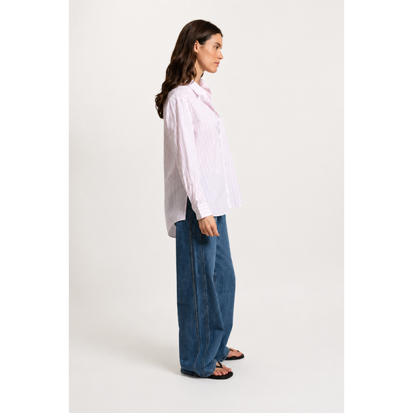 a woman wearing a purple and white button up stripe shirt on a white background
