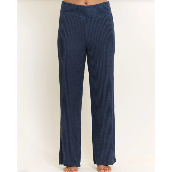 A person wearing dark navy ribbed knit pants, shown from the waist down against a plain light background.