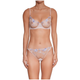 A model wearing a sheer nude lace lingerie set with light blue floral embroidery, featuring a bra and matching panties, against a plain white background.