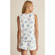 Woman wearing a sleeveless top and shorts with blue floral patterns on a beige background