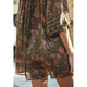 Person wearing a floral dress with a pattern of swans and flowers.