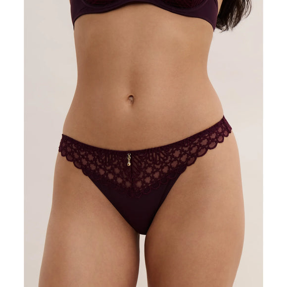 Lace underwear worn by a person on a plain background