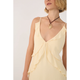 Woman wearing a light yellow dress with ruffled details on a plain background