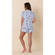 Woman wearing a light blue pajama set with a butterfly pattern on a beige background