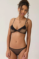 Woman wearing a black lingerie set against a plain background