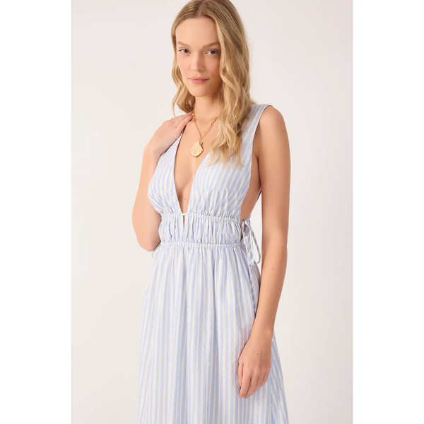 Woman wearing a white sleeveless dress with a plunging neckline on a plain background