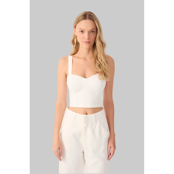 Woman wearing a white crop top and pants on a white background