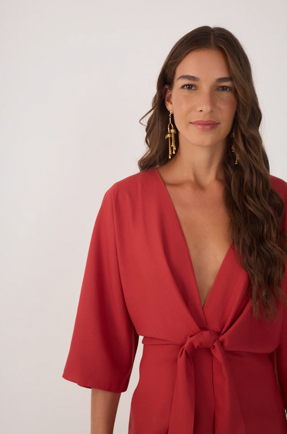 Woman wearing a red dress with a plain background