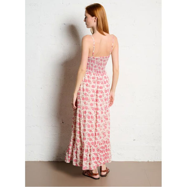 Woman wearing a floral dress against a white wall