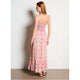 Woman wearing a floral dress against a white wall