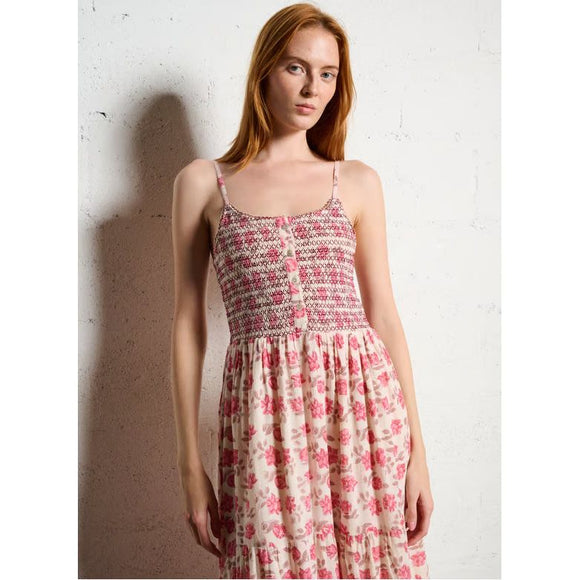 Woman wearing a floral dress against a white wall