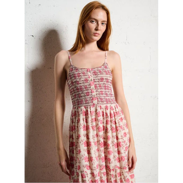 Woman wearing a floral dress against a white wall