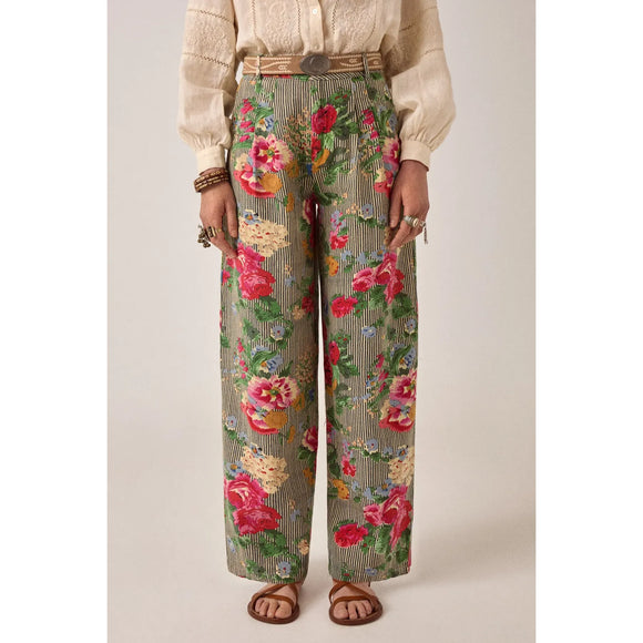 Person wearing floral-patterned pants with a plain background