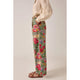 Person wearing floral pants with a neutral background