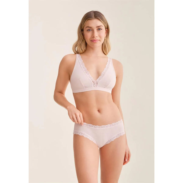 Woman wearing a light pink bra and underwear set on a plain background