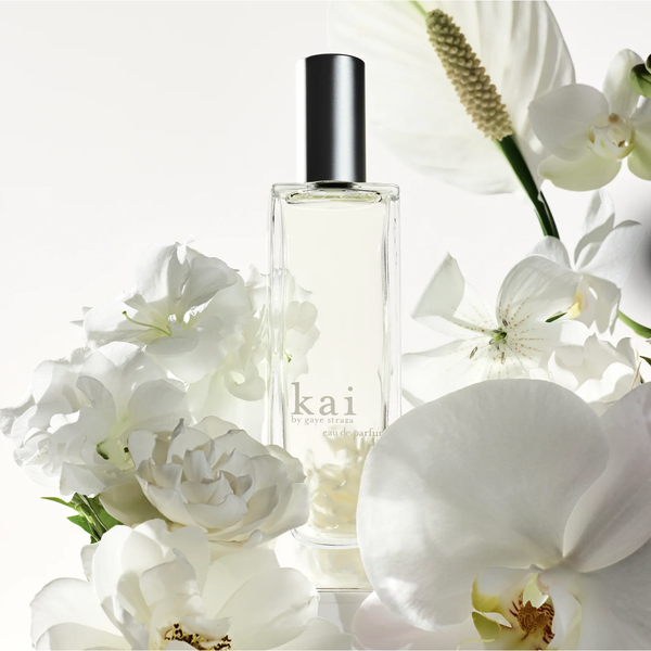 Perfume bottle labeled 'kai' surrounded by white flowers on a light background