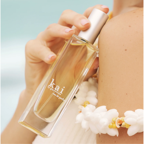 Person holding a 'kai' perfume bottle with a blurred background