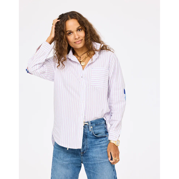 Woman wearing a white striped shirt and blue jeans on a white background