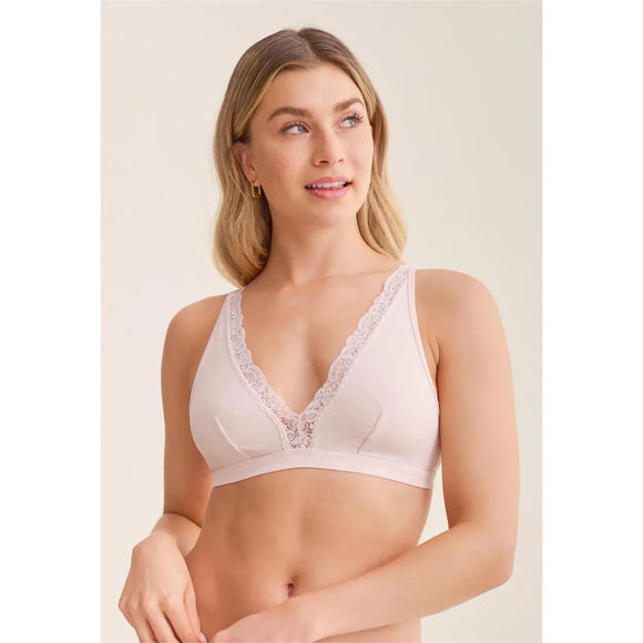 Woman wearing a light pink bralette with lace details on a beige background