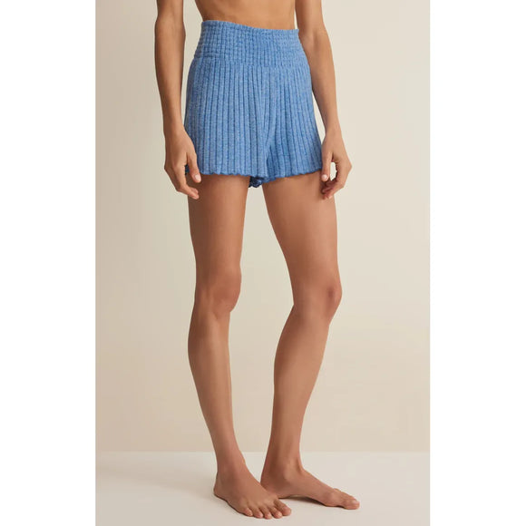 Person wearing blue shorts on a beige background